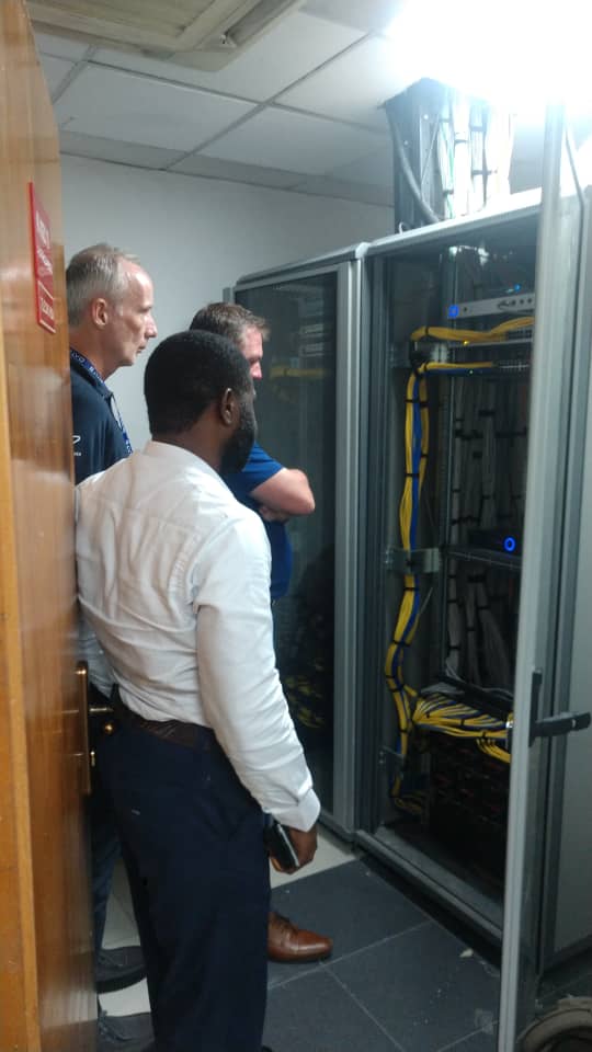 Engineers inspecting a structured LAN cabling rack before handover