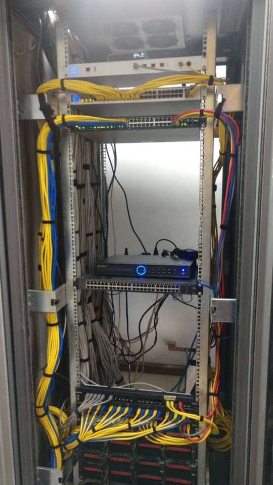 Structured LAN cabling rack with organized network equipment and patch cables